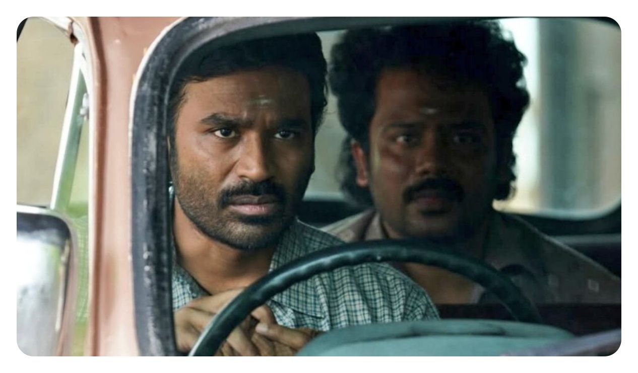 A gripping official still from the movie Kara featuring actor Dhanush in a rural heist setup.