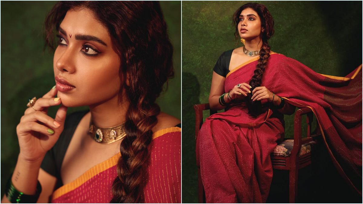 Red Saree Glamour! — "சிவப்பு புடவையில் சொக்க வைக்கும் மாரியம்மா!" — கருப்பு பிளவுஸ் காம்பினேஷனில் துஷாரா விஜயன் நடத்திய லேட்டஸ்ட் போட்டோஷூட்; கியூட் புகைப்படங்கள் வைரல்! 5 Actress Dushara Vijayan posing elegantly next to architectural shadows wearing a bright red saree and a matching black blouse.